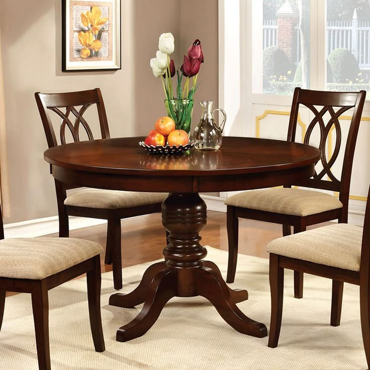 Table ronde en bois brun dressée avec des fleurs et des fruits